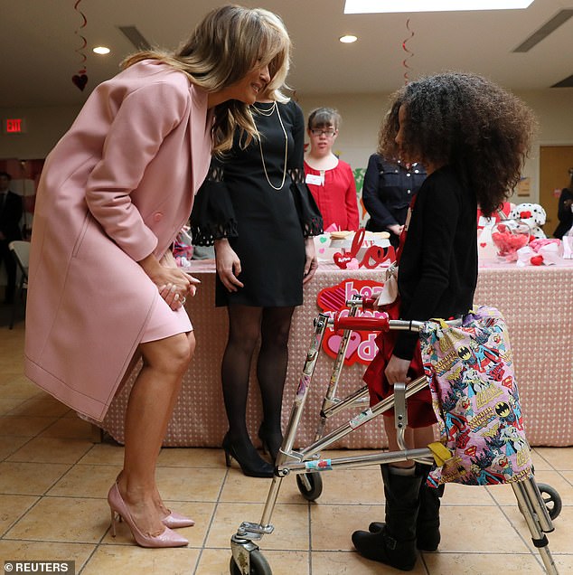 Chatting away: The first lady squatted down so they would be at eye level with the nine-year-old named Amber, whom she had met at last year