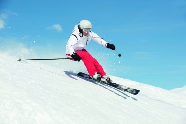 Девушка спускается с горы на лыжах