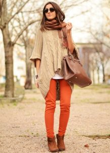 Девушка в оранжевых брюках и длинном свитере