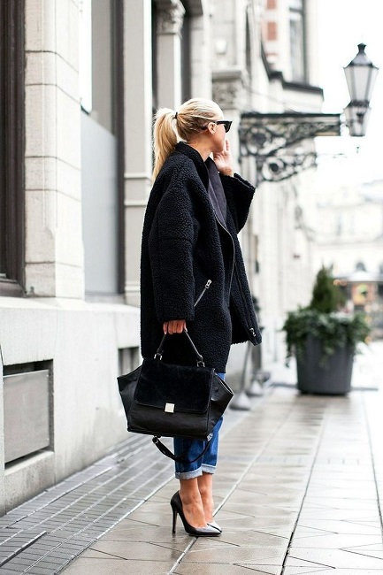 Девушка в черном пальто, джинсах и черных лодочках