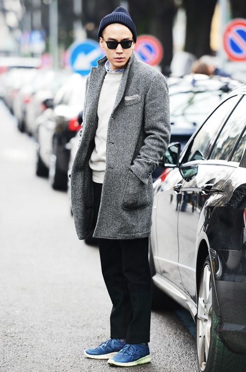 мужчина в сером пальто, кроссовках и шапке