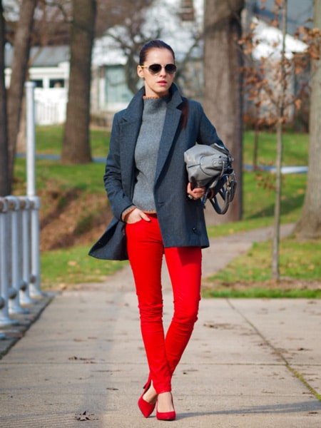 Девушка в сером пальто и красных брюках