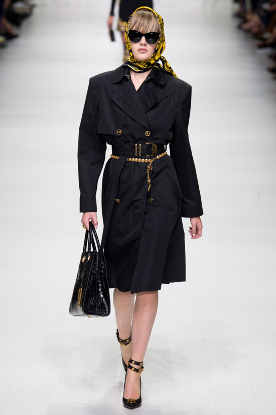 Модель с модного показа Versace в черном плаще с ремнем и платок