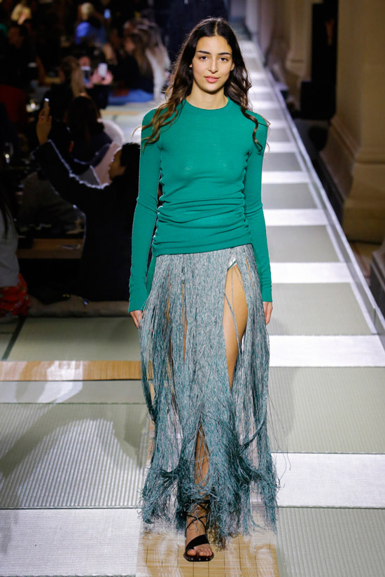Модель в голубой юбке с бахромой и зеленой кофте от H&M