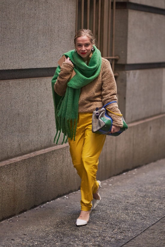 Девушка в желтых брюках, бежевый свитер и зеленый шарф оверсайз
