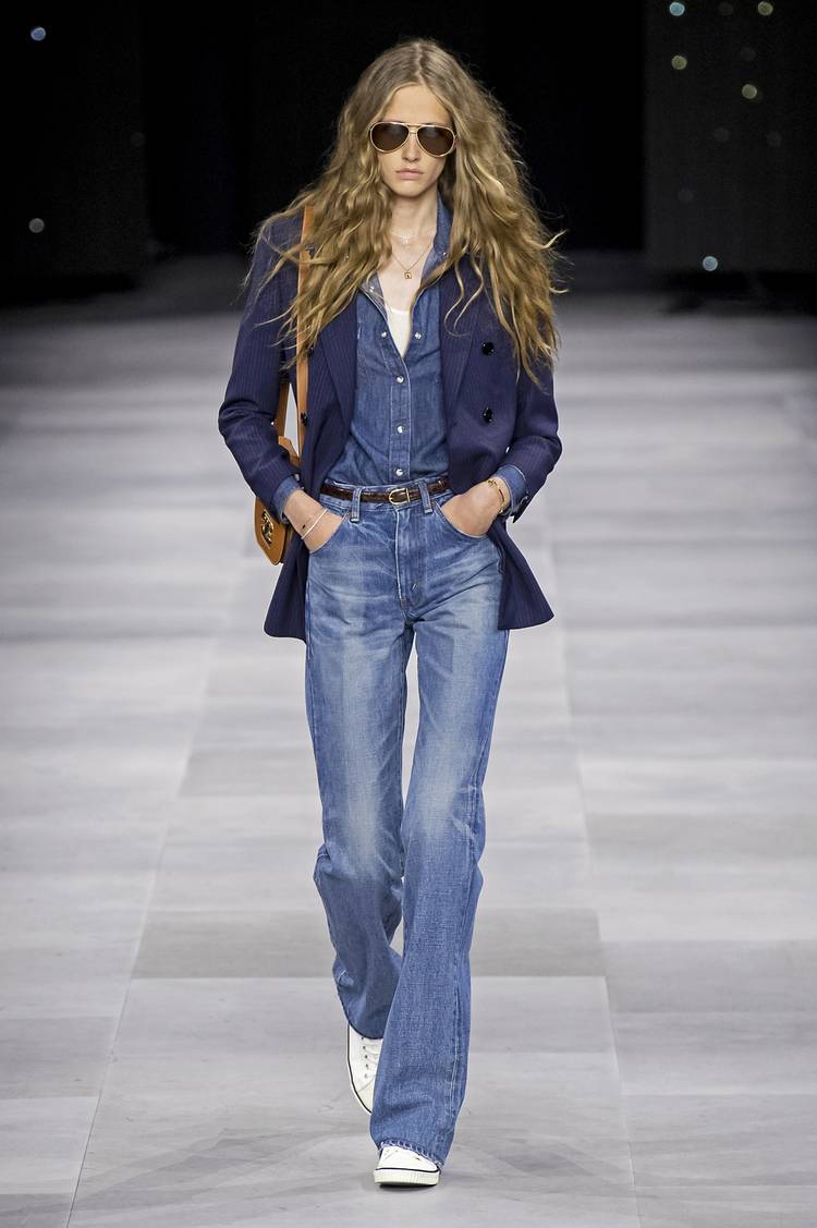 Модель в синих джинсах, джинсовая рубашка и белые кеды