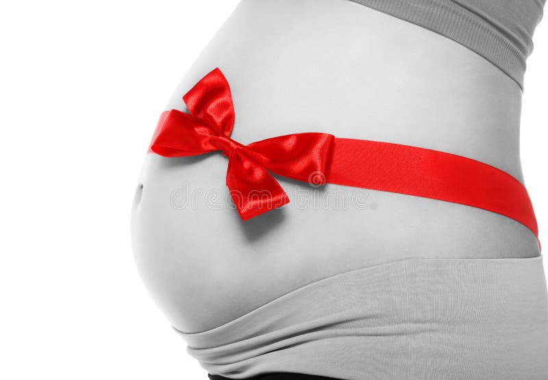Belly of a pregnant woman tied with a red bow. On a white background royalty free stock photos
