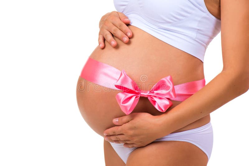 Close-up of pregnant belly with pink ribbon bow for newborn baby girl. Concept of pregnancy royalty free stock photos