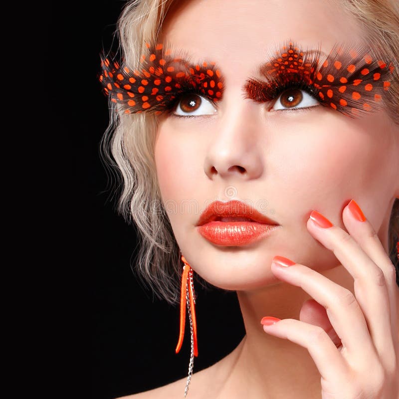 Fashion Blonde Model with Long Orange Eyelashes. Professional Makeup for Halloween. Portrait royalty free stock image