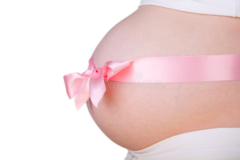 It is a girl. Isolated 29-weeks pregnant belly with pink bow over it stock images