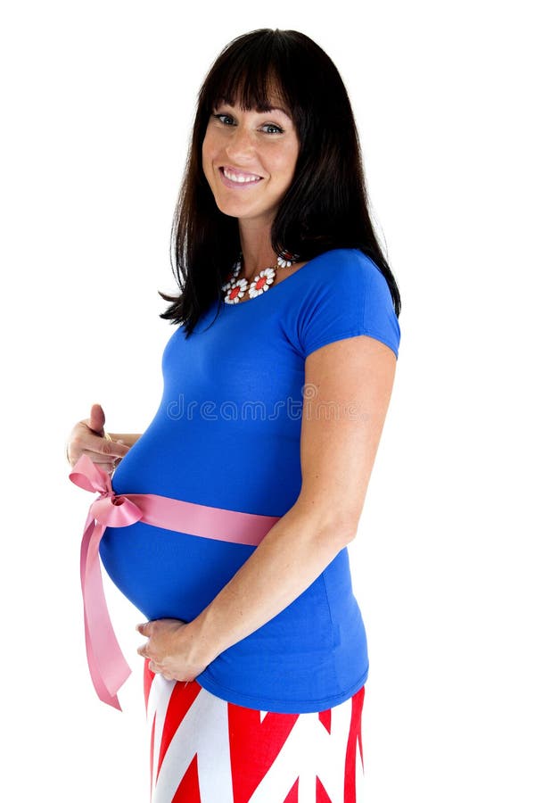 Happy pregnant woman showing off her belly with a pink bow. Happy pregnant woman showing off her belly with wrapped in a pink bow stock images