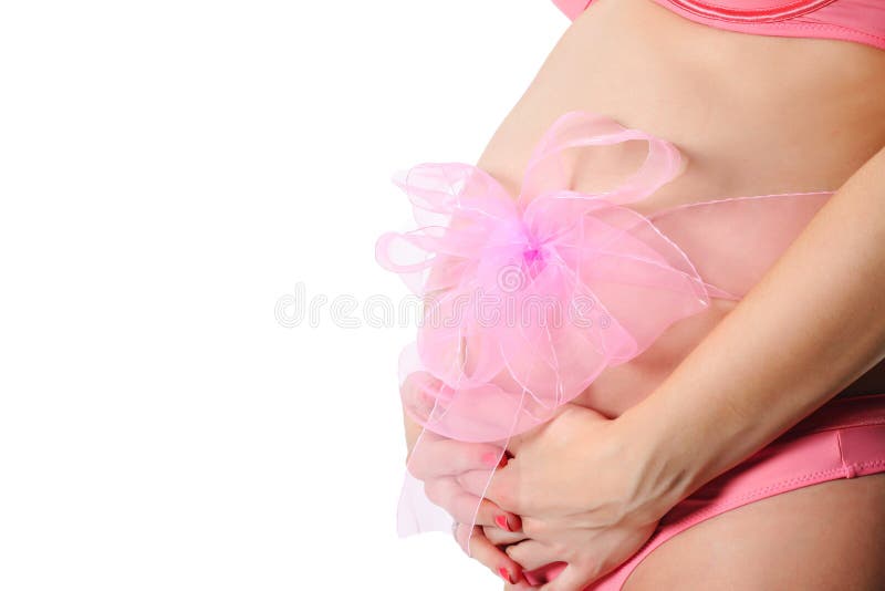 Pregnant girl with a pink bow on the white background. isolated. Pregnant girl untie a bow on the white background. isolated on white background stock photos