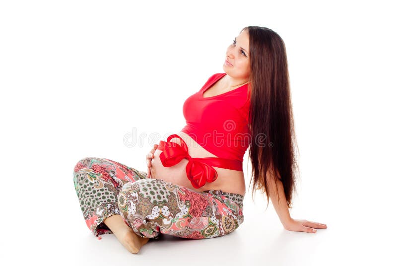 Pregnant girl with a red bow on her stomach. On white background stock images