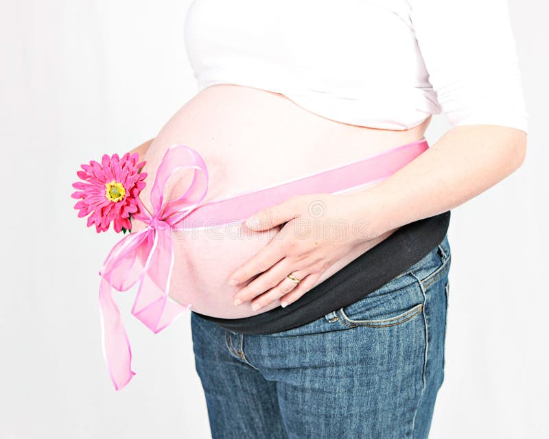 Pregnant woman with pink bow. Pink ribbon tied in bow around stomach of pregnant woman, isolated on white background stock photo
