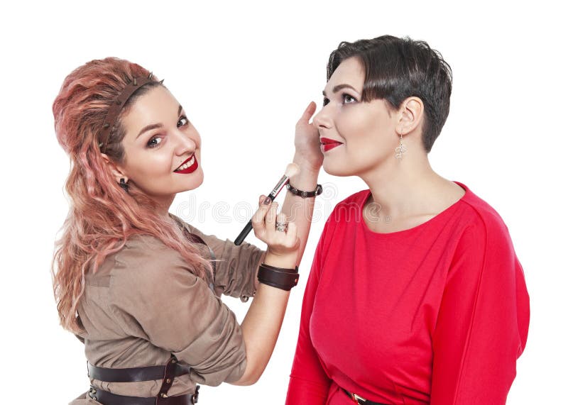 Professional makeup artist making makeup to a model isolated. On white background royalty free stock images