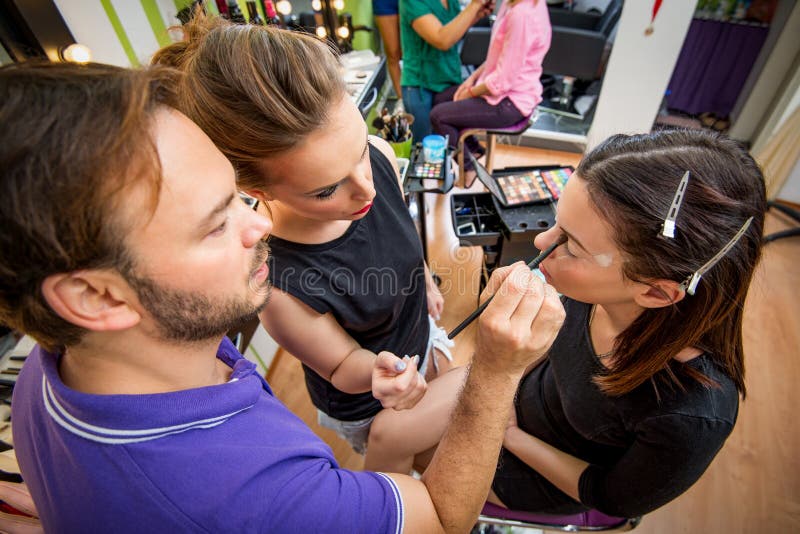 School Of Makeup. Makeup teacher helping students training to become makeup artist royalty free stock photos